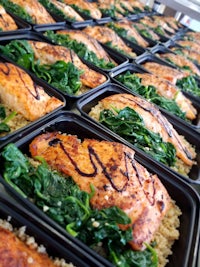 a tray of salmon, spinach, and quinoa