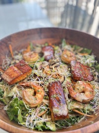 a wooden bowl with a salad in it