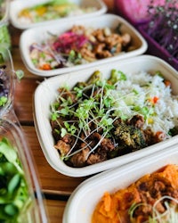 a line of plastic containers filled with different types of food